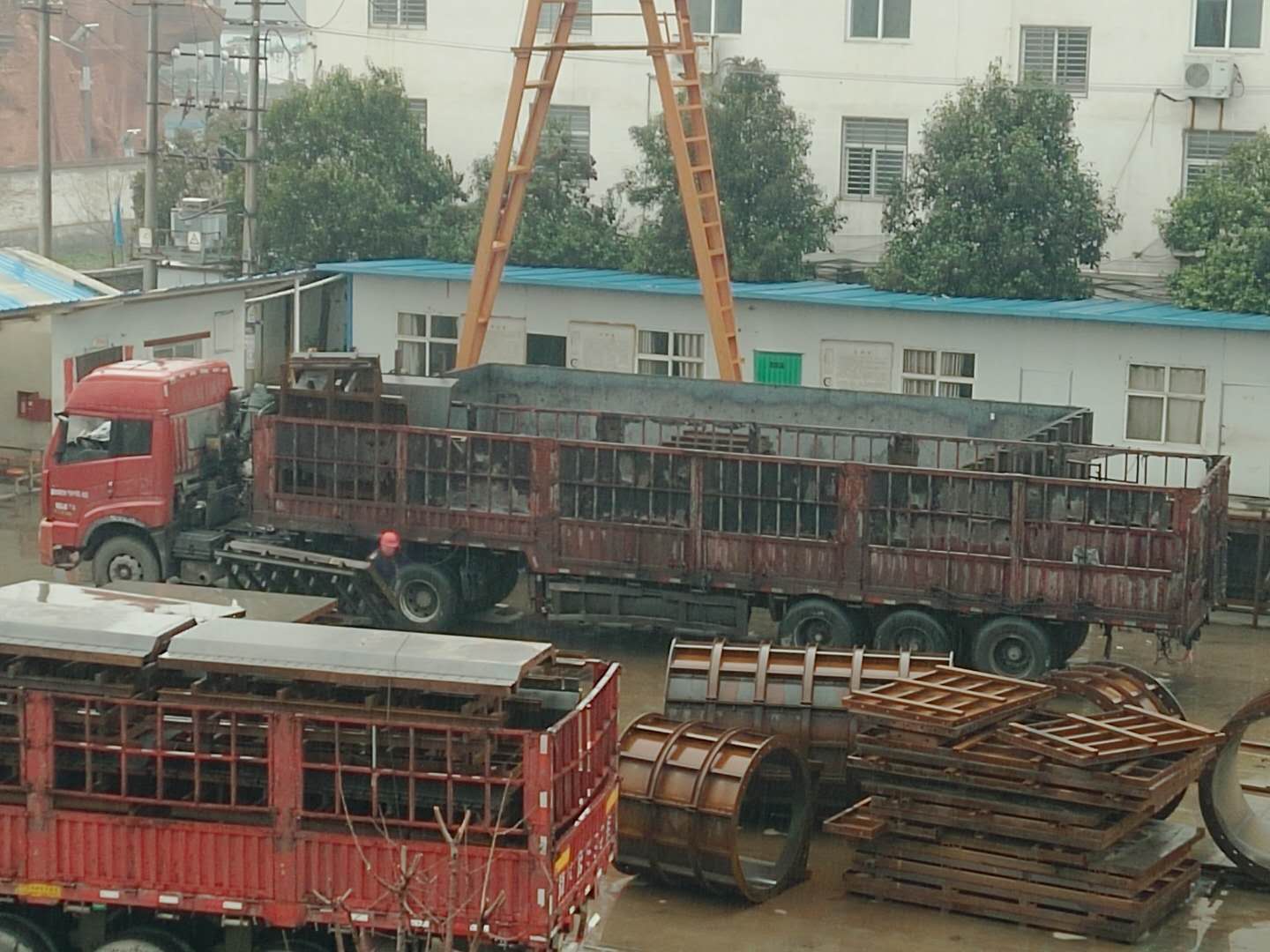 下雨天，系梁模板廠家的員工冒雨裝貨